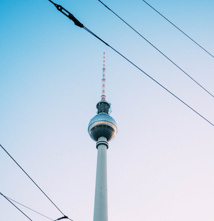 Stunning view of Berlin TV Tower with clear blue sky backdrop and intersecting cables.