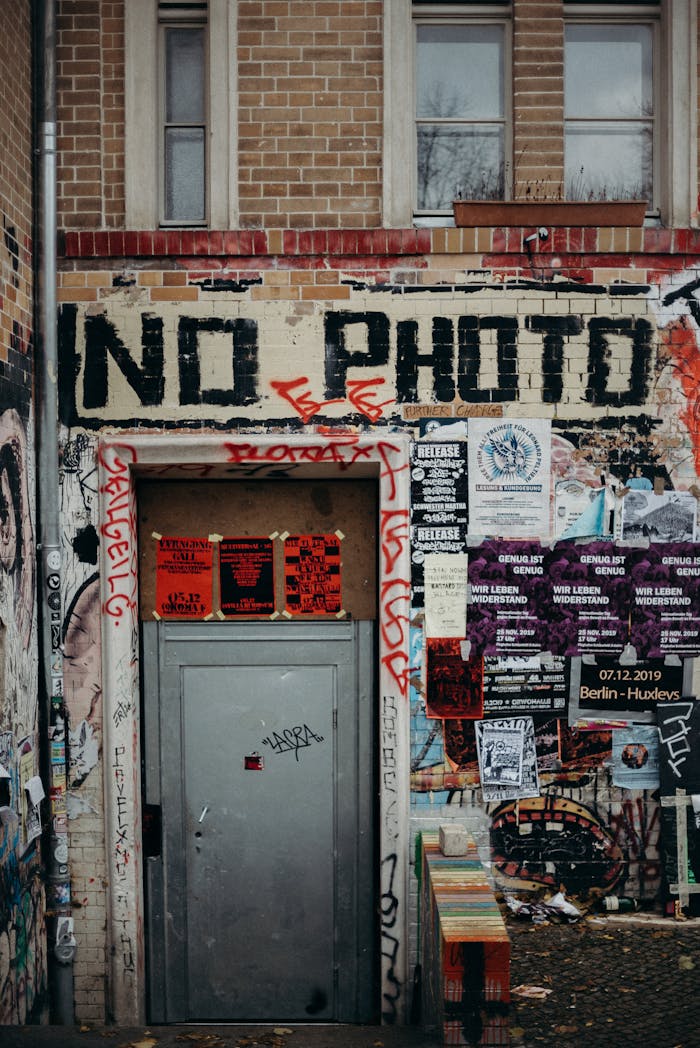 Street art with graffiti and posters at a Berlin building entrance.